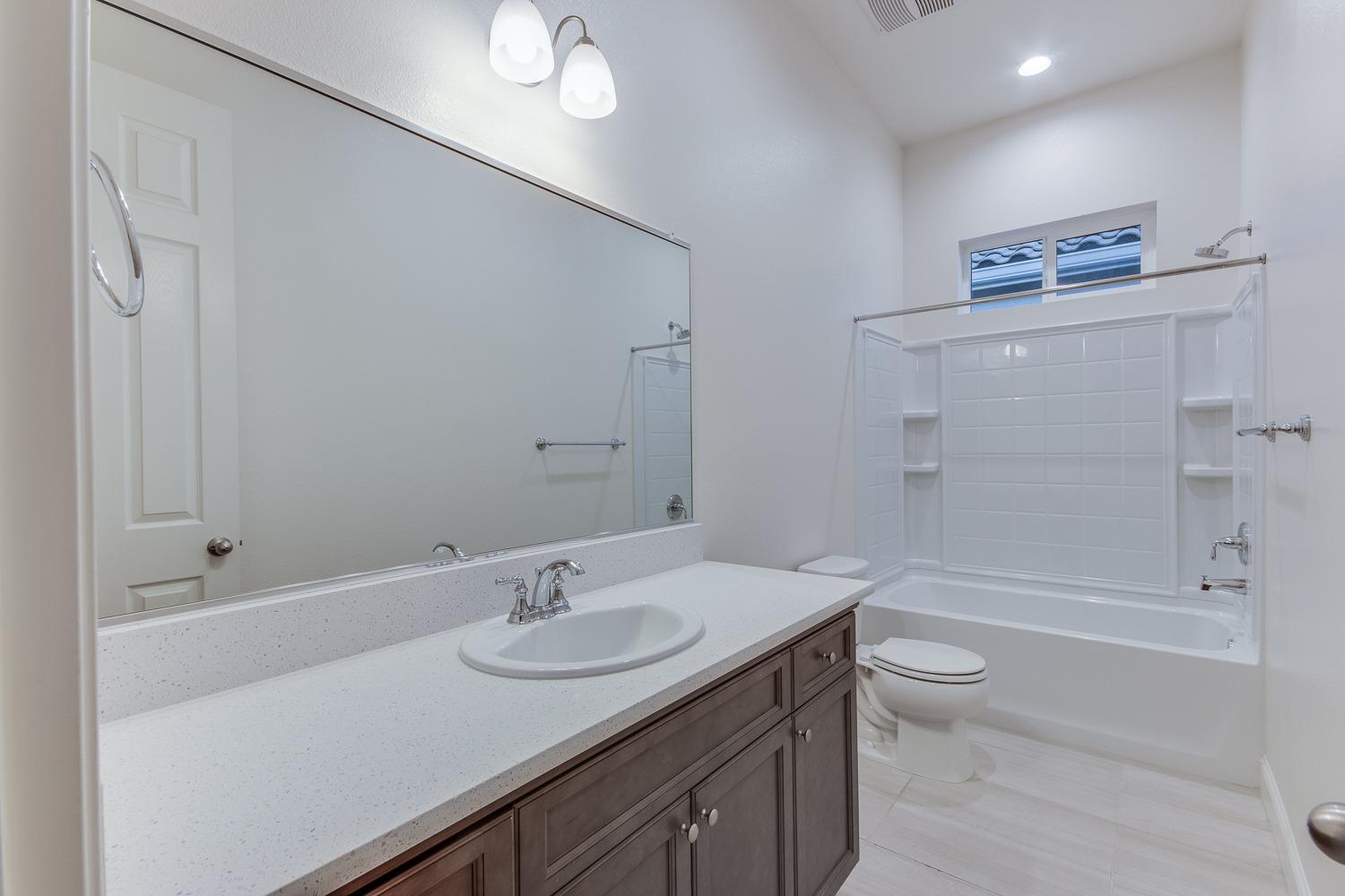 3027 Twain Avenue Clovis, CA 93619 - Photo 9 of 32 a bathroom with a sink a toilet and shower