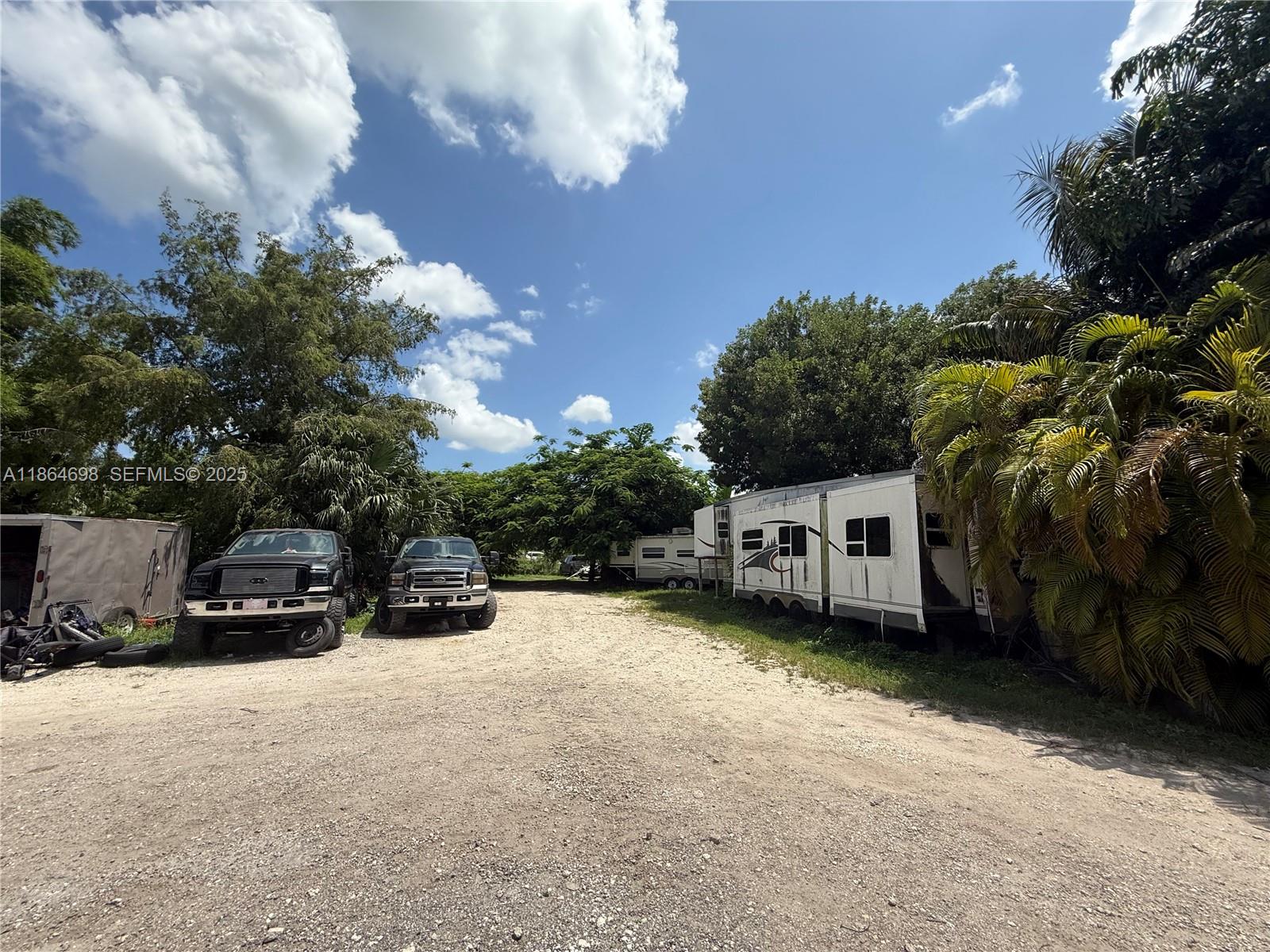 15765 Southwest 206th Avenue Miami, FL 33187 - Photo 25 of 57 a view of a white house with a yard and parking space