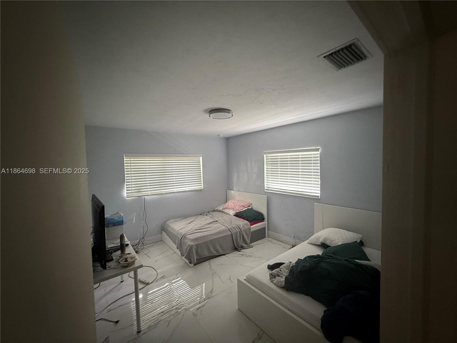 15765 Southwest 206th Avenue Miami, FL 33187 - Photo 52 of 57 a bedroom with two beds and a lamp