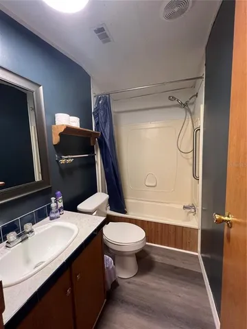 a bathroom with a sink a toilet a mirror and shower
