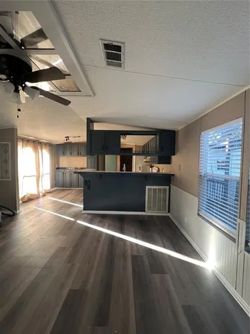 a kitchen with stainless steel appliances kitchen island granite countertop a stove and a wooden floors
