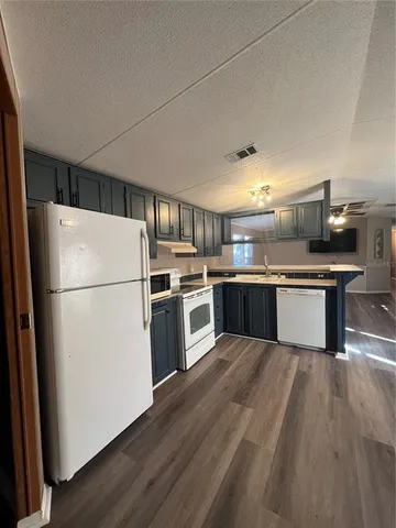 a kitchen with stainless steel appliances granite countertop a refrigerator a stove a sink and a microwave