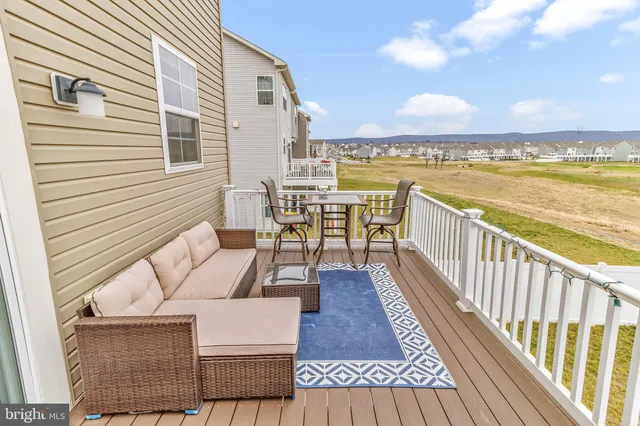 a view of a balcony with wooden floor and outdoor seating