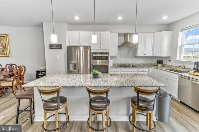 a kitchen with refrigerator a sink and chairs