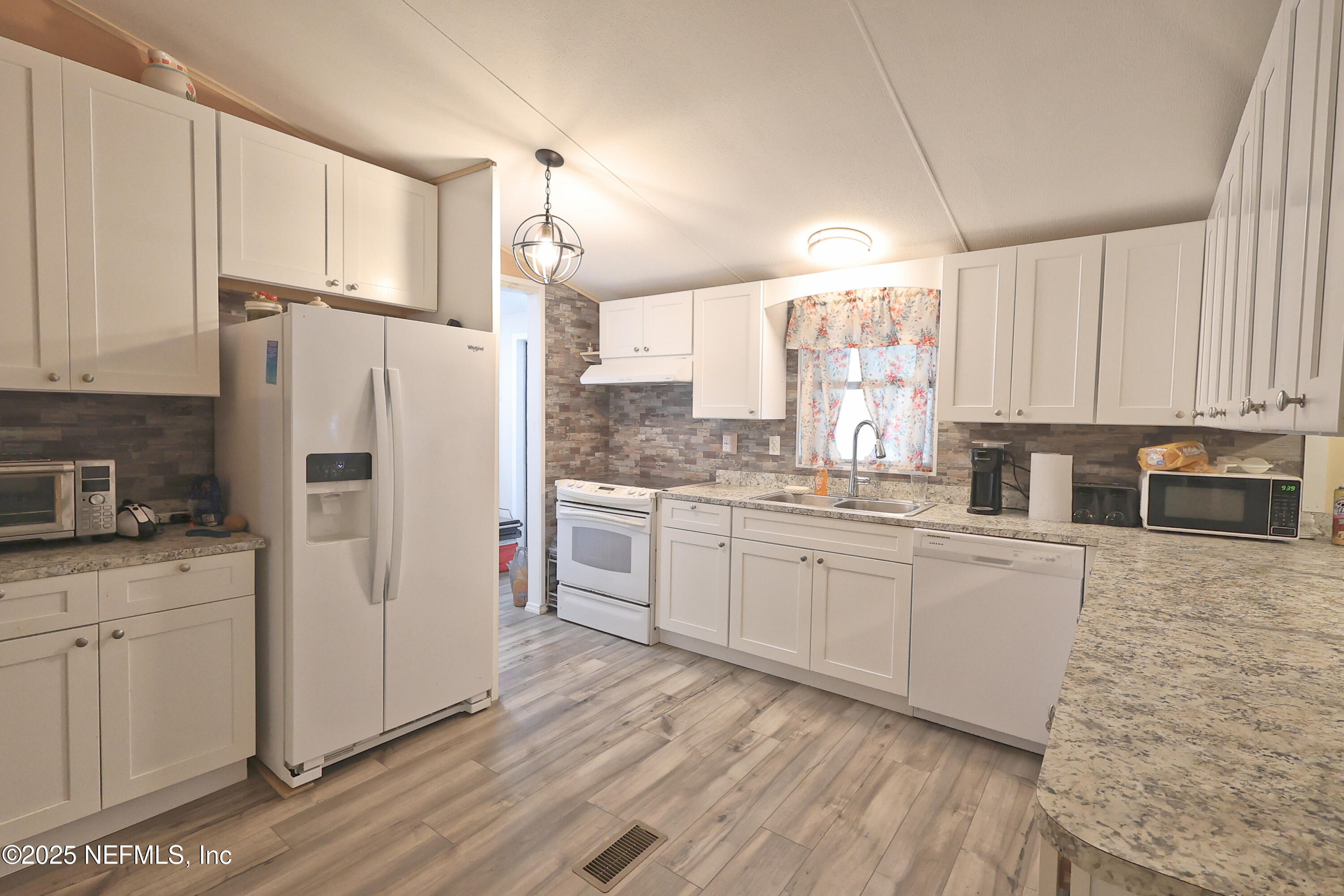 138 Edgewater Road Satsuma, FL 32189 - Photo 22 of 45 a kitchen with granite countertop white cabinets and white appliances