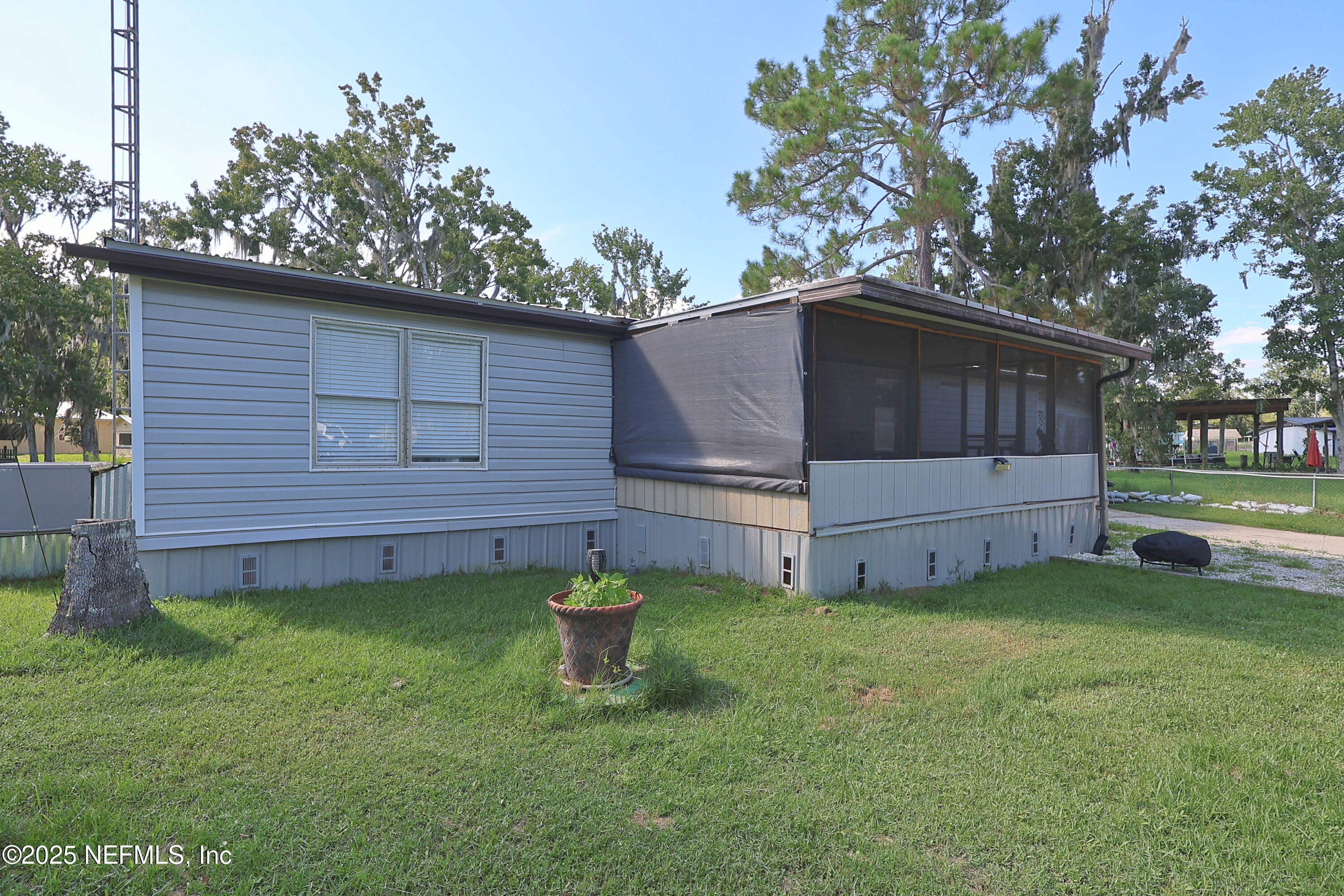 138 Edgewater Road Satsuma, FL 32189 - Photo 5 of 45 a view of a backyard with a large tree and a fire pit