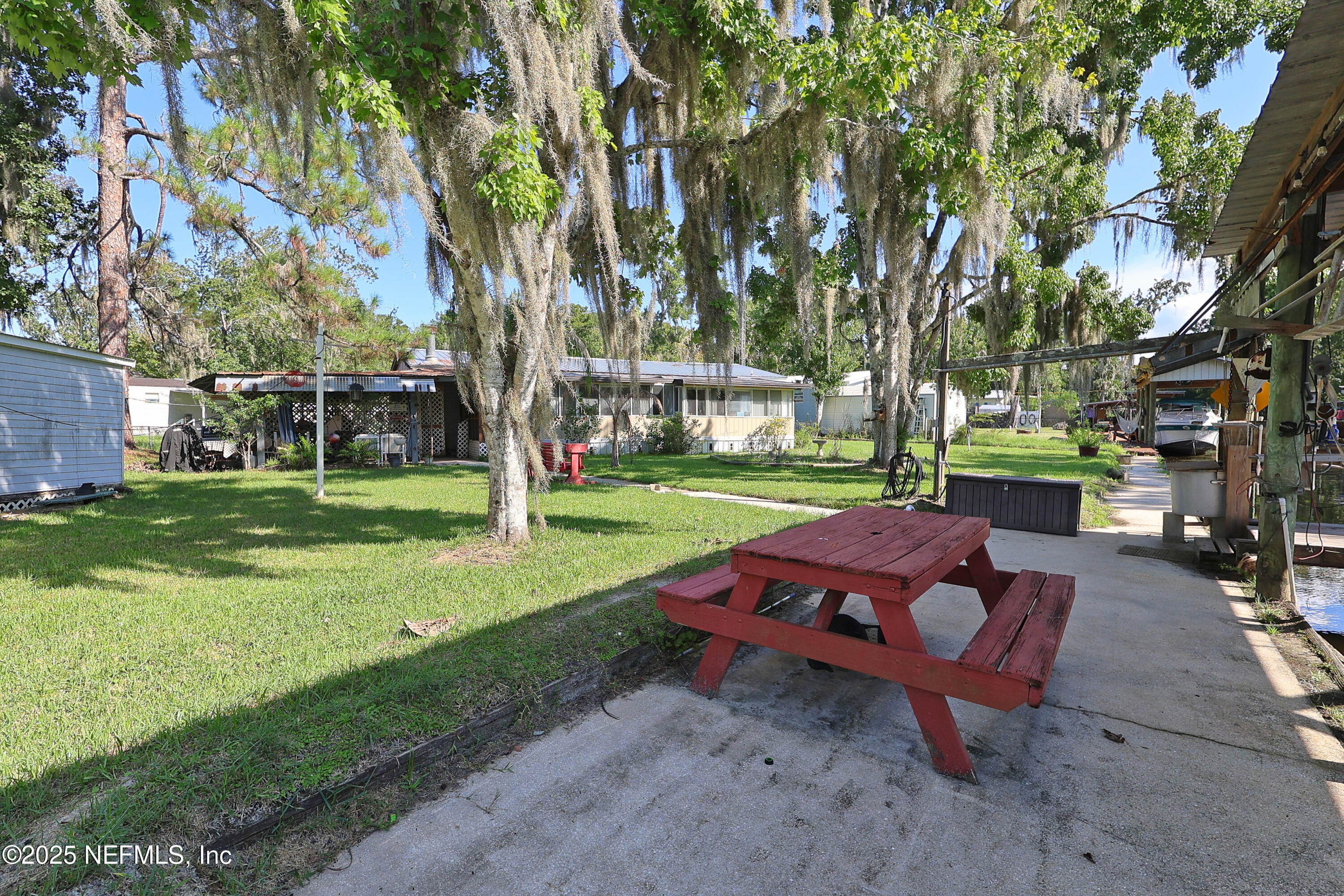 138 Edgewater Road Satsuma, FL 32189 - Photo 7 of 45 a backyard of a house with barbeque oven table and chairs