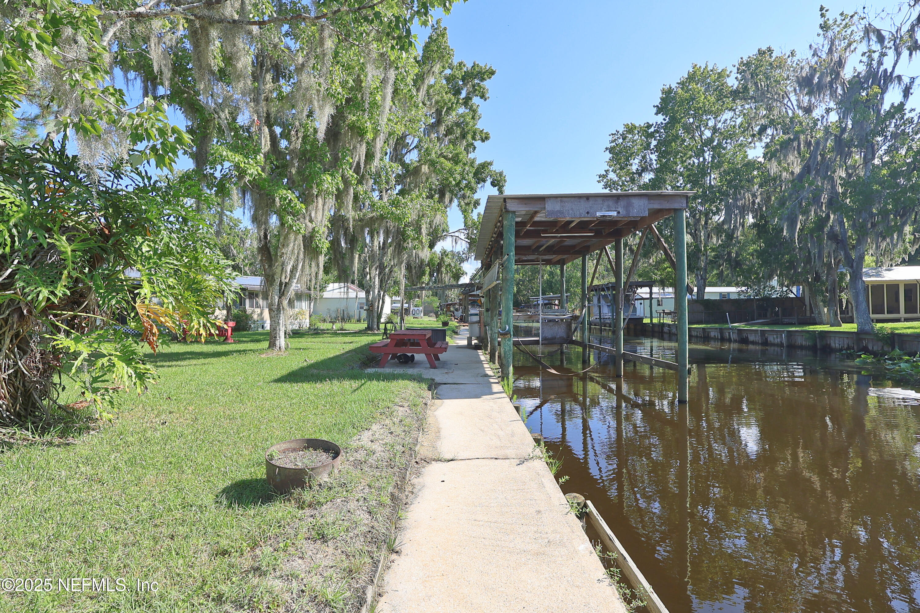 138 Edgewater Road Satsuma, FL 32189 - Photo 10 of 45 a view of a lake with a bench under an umbrella