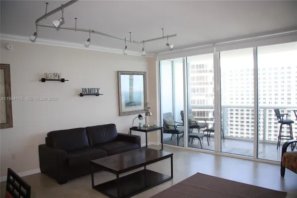 a living room with furniture and a floor to ceiling window