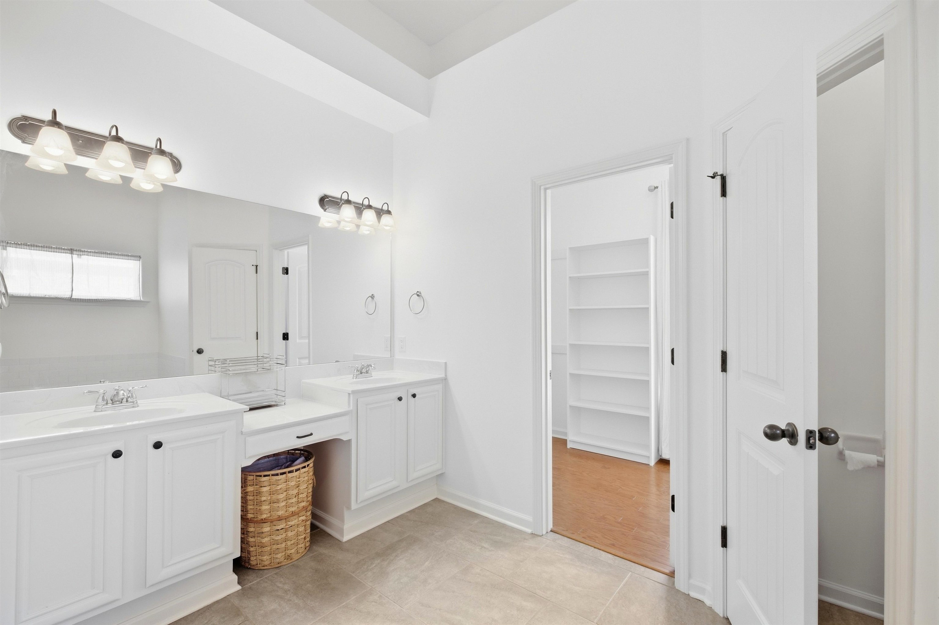 7920 Pips Ridge Lane Bartlett, TN 38133 - Photo 16 of 40 Dual vanities with integrated sinks, white cabinetry, and a full-width mirror