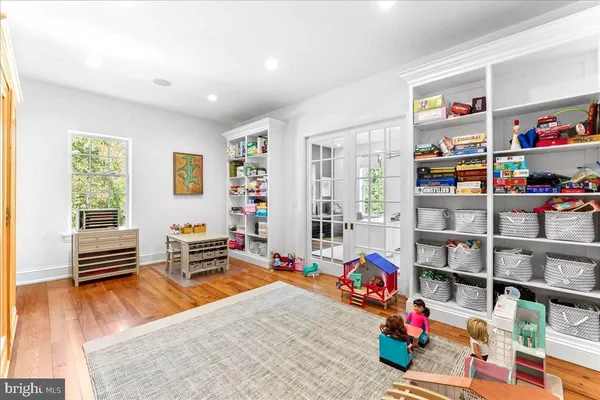 a living room with a black white checkered floor with a dining table and chair