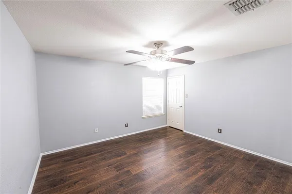 a view of a room with wooden floor and a ceiling fan