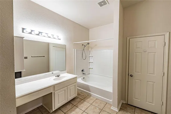 a bathroom with a double vanity sink a mirror and a bathtub