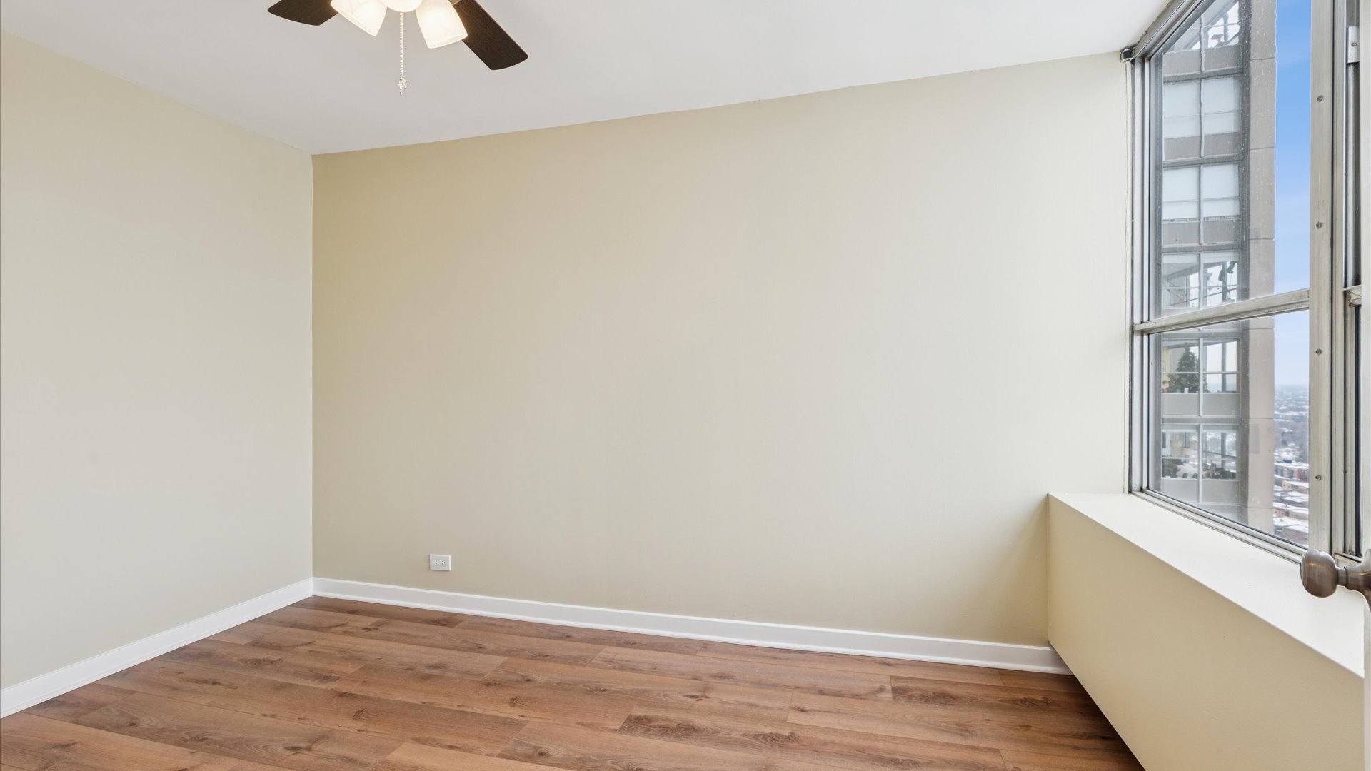 655 West Irving Park Road, Unit 3704 Chicago, IL 60613 - Photo 16 of 36 a view of an empty room with wooden floor and a window
