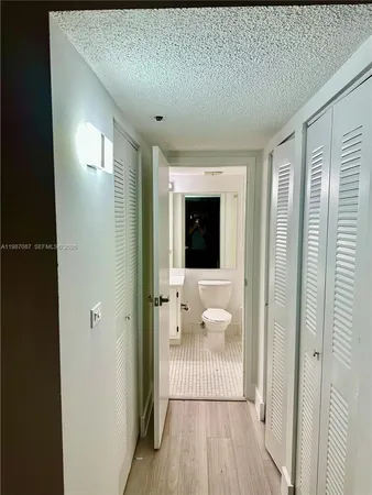 a view of a hallway with wooden floor and windows