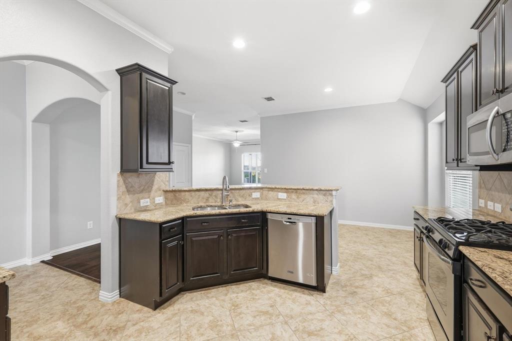 3513 Durango Root Court Fort Worth, TX 76244 - Photo 13 of 34 a view of a kitchen with stainless steel appliances granite countertop a sink stove and refrigerator