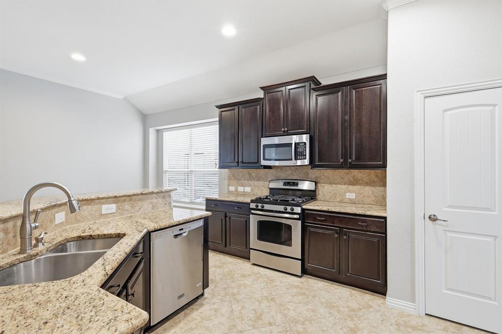 3513 Durango Root Court Fort Worth, TX 76244 - Photo 14 of 34 a kitchen with stainless steel appliances granite countertop a sink stove and cabinets