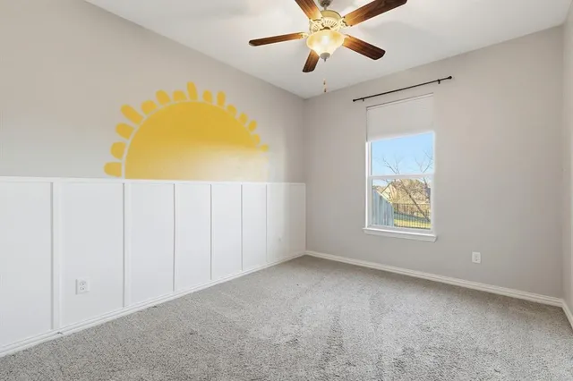 an empty room with a window and a ceiling fan