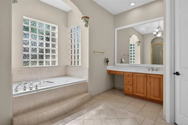 a bathroom with a granite countertop sink and a bathtub