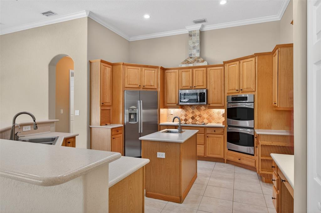 15601 Southwest 15th Street Davie, FL 33326 - Photo 25 of 52 a kitchen with stainless steel appliances a stove refrigerator sink and cabinets