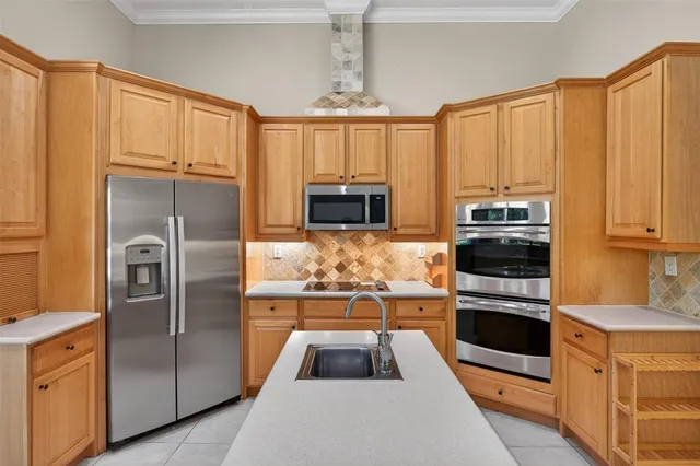 a kitchen with granite countertop a refrigerator and a stove top oven