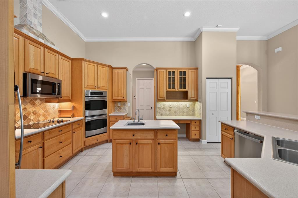 15601 Southwest 15th Street Davie, FL 33326 - Photo 7 of 52 a kitchen with stainless steel appliances kitchen island granite countertop a stove top oven a sink dishwasher a dining table and chairs