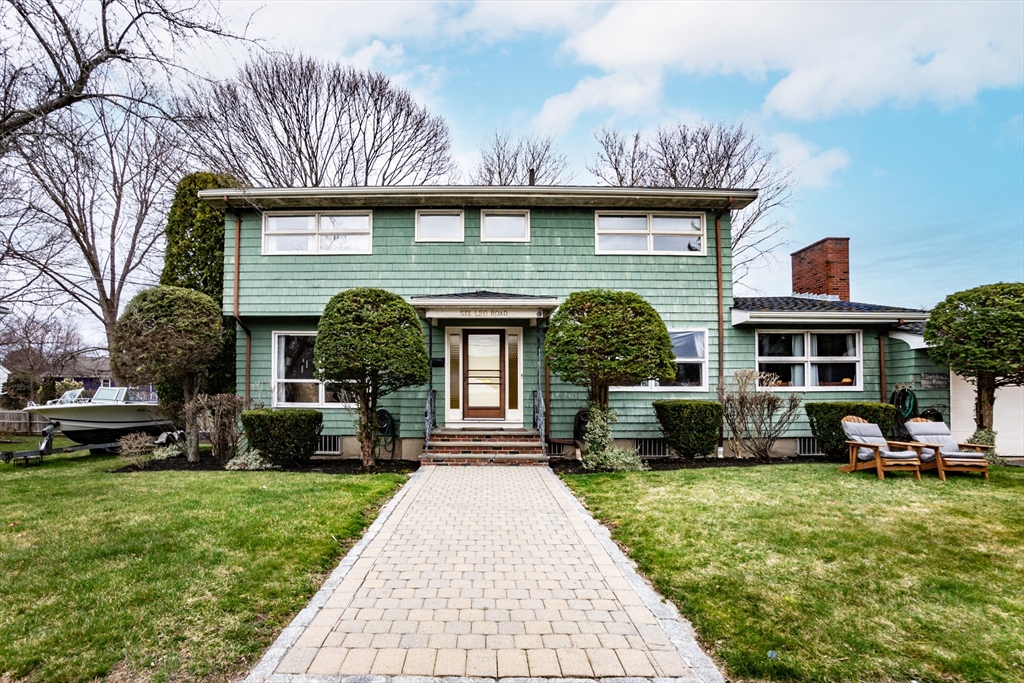 a front view of a house with a garden and plants