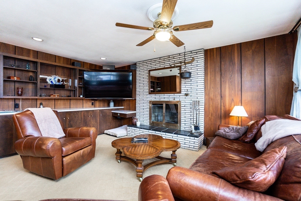 6 Leo Road Marblehead, MA 01945 - Photo 12 of 36 a living room with furniture a fireplace and a flat screen tv