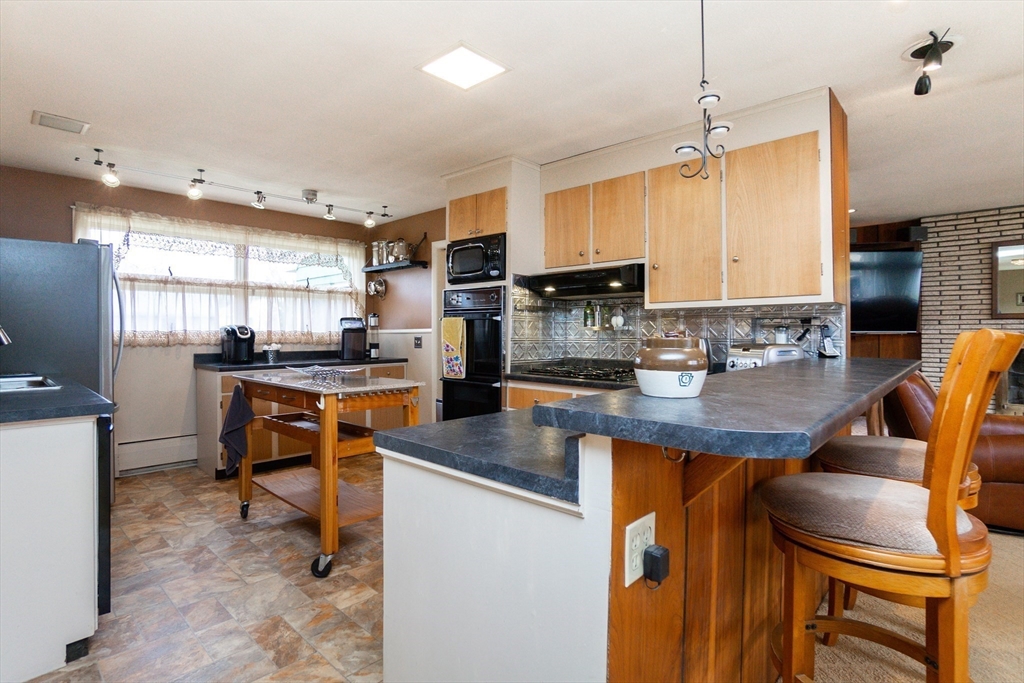 6 Leo Road Marblehead, MA 01945 - Photo 14 of 36 a kitchen with stainless steel appliances granite countertop a sink a stove a refrigerator cabinets and a dining table