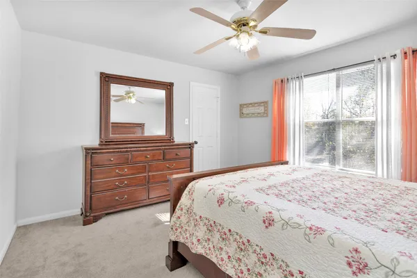 a bedroom with a bed and a flat tv screen on a dresser