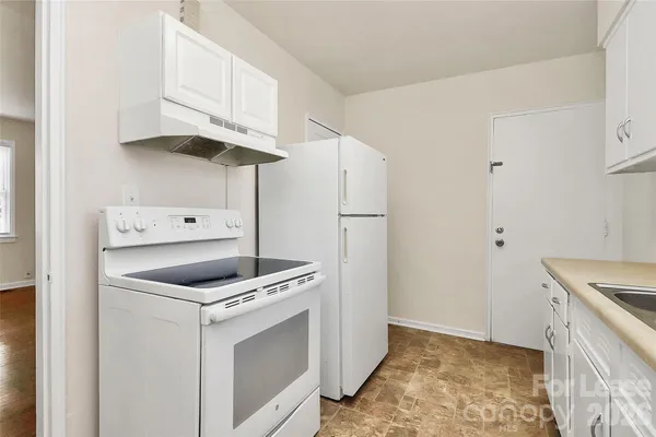 a kitchen with white cabinets and white appliances