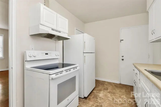 a kitchen with white cabinets and white appliances