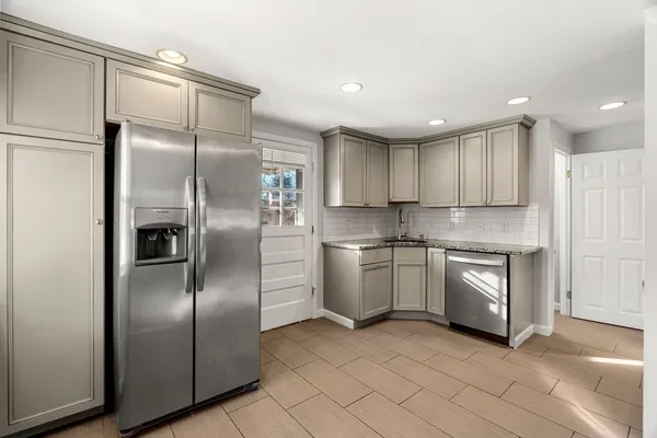 a kitchen with stainless steel appliances granite countertop a refrigerator a sink and a stove
