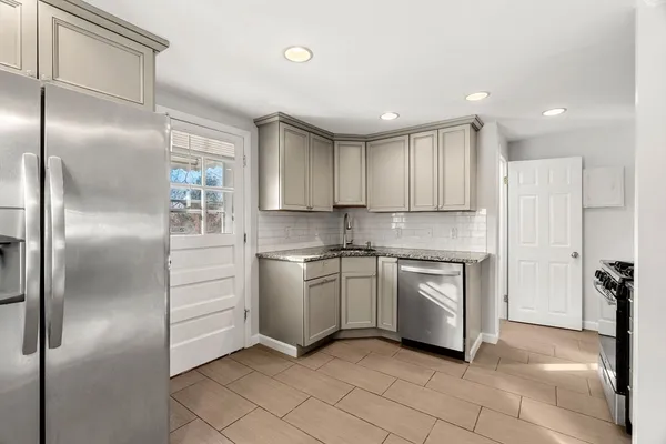 a kitchen with a refrigerator and white cabinets