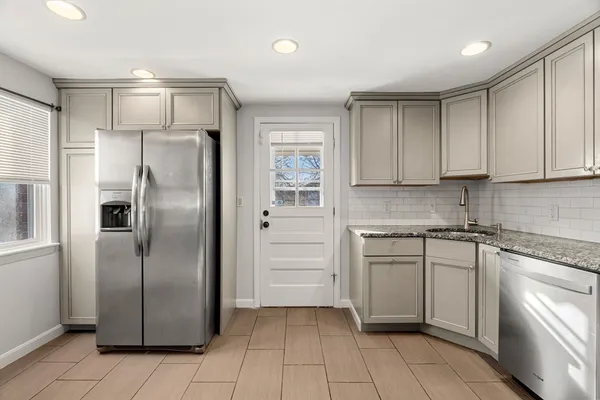 a kitchen with stainless steel appliances granite countertop a refrigerator and a stove top oven