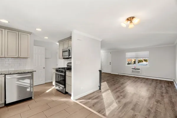 a kitchen with granite countertop a refrigerator and a stove top oven