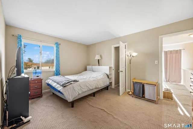 a bedroom with a bed couch and a window