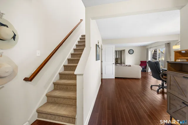 a view of a livingroom with wooden floor and stairs