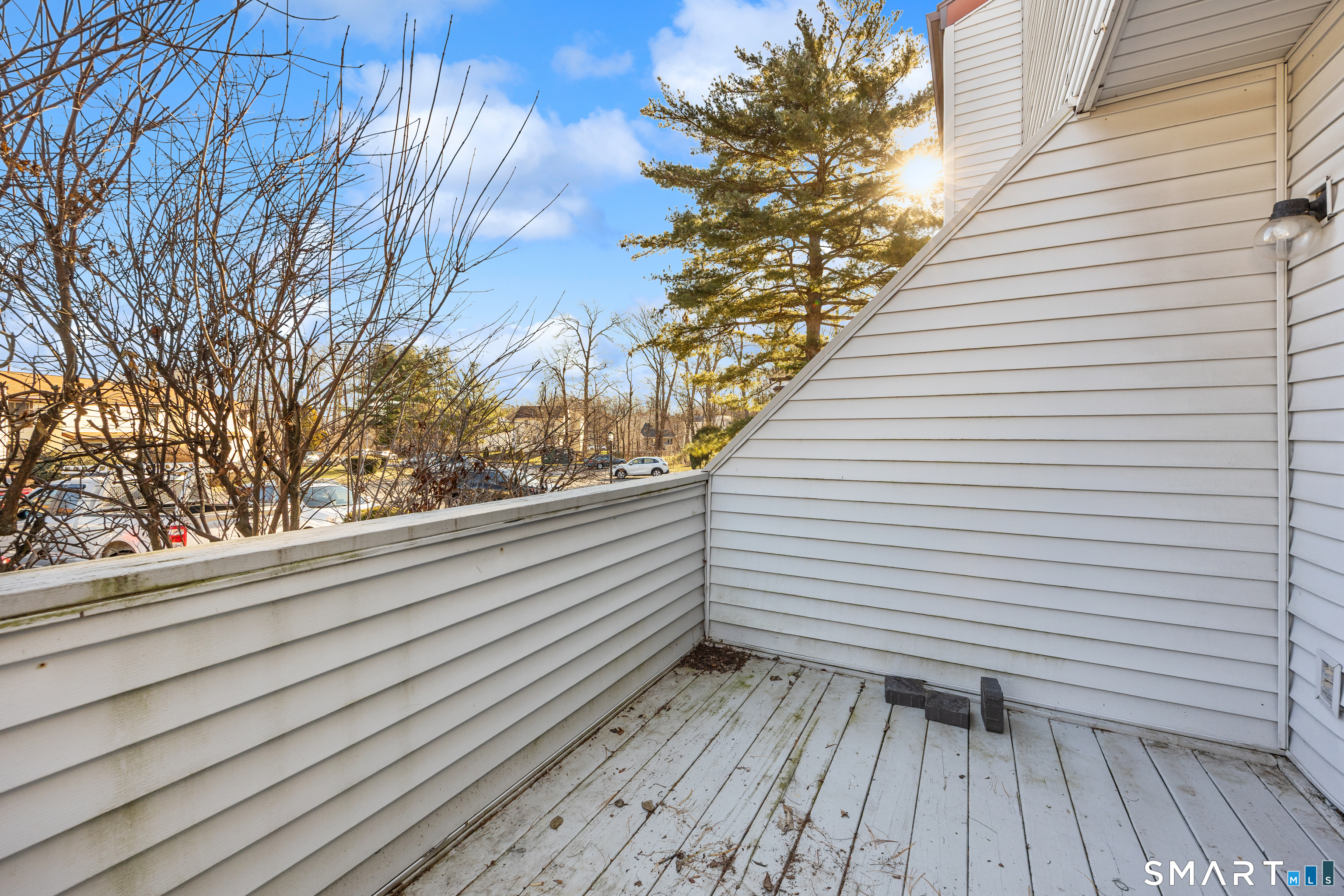 229 Cottonwood Road, Unit 229 Newington, CT 06111 - Photo 23 of 24 a view of a roof deck with wooden floor and fence and a floor to ceiling window