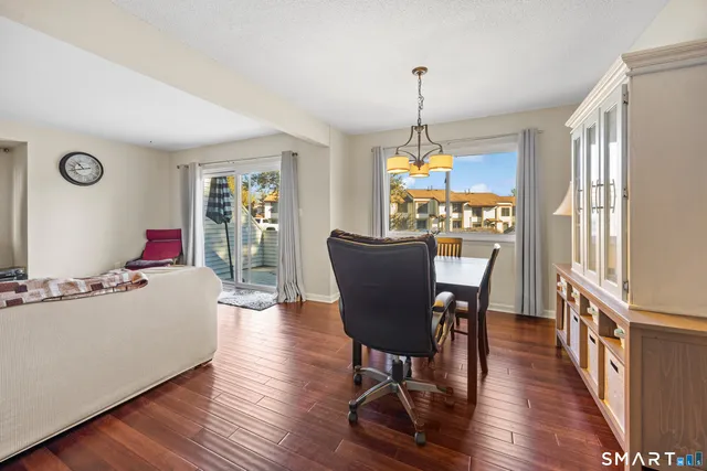 a dining room with furniture a chandelier and wooden floor