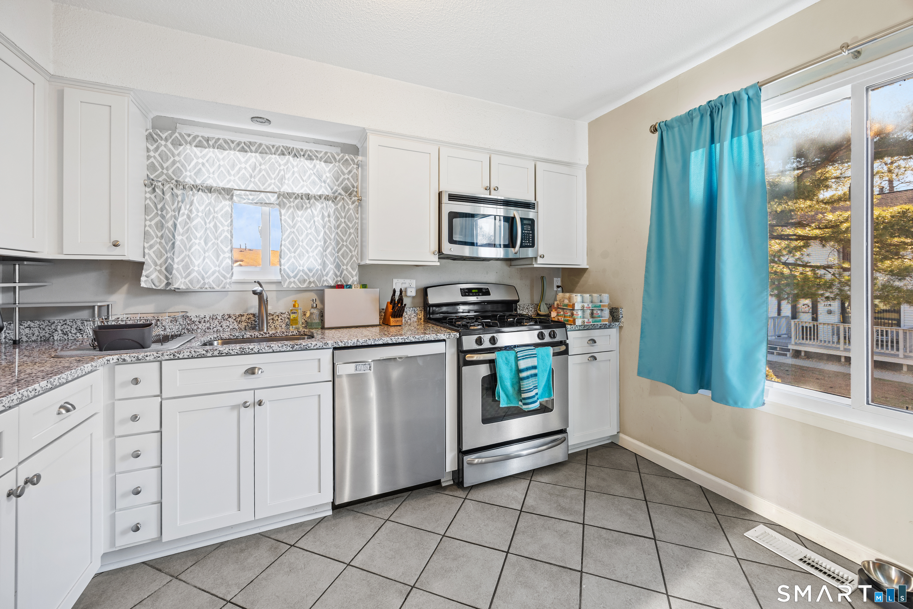 229 Cottonwood Road, Unit 229 Newington, CT 06111 - Photo 5 of 24 a kitchen with stainless steel appliances granite countertop a stove a sink and a refrigerator