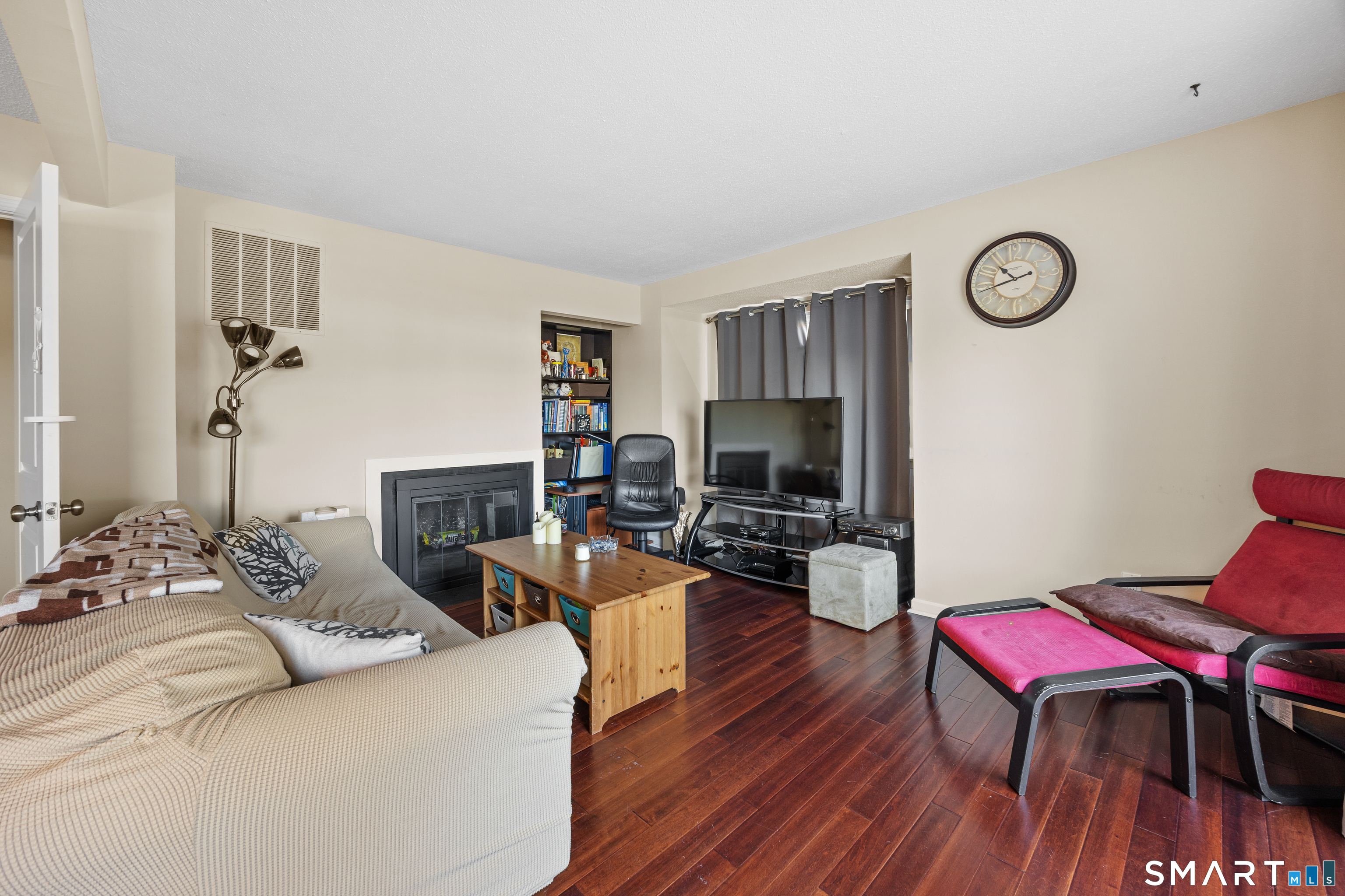 229 Cottonwood Road, Unit 229 Newington, CT 06111 - Photo 7 of 24 a living room with furniture a fireplace and a flat screen tv