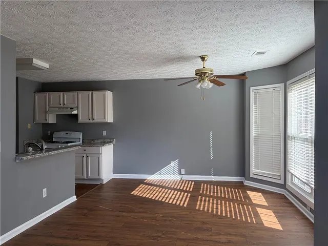 a view of a kitchen with a sink wooden floor and a living room