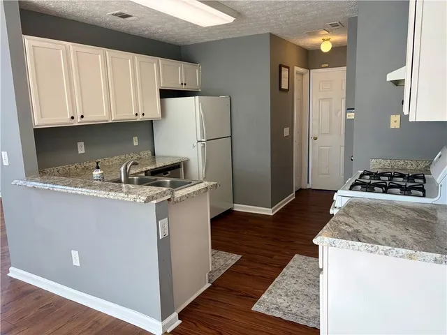 a kitchen with a refrigerator and a stove top oven