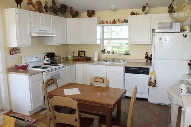 a kitchen with a white cabinets a stove a sink and white appliances