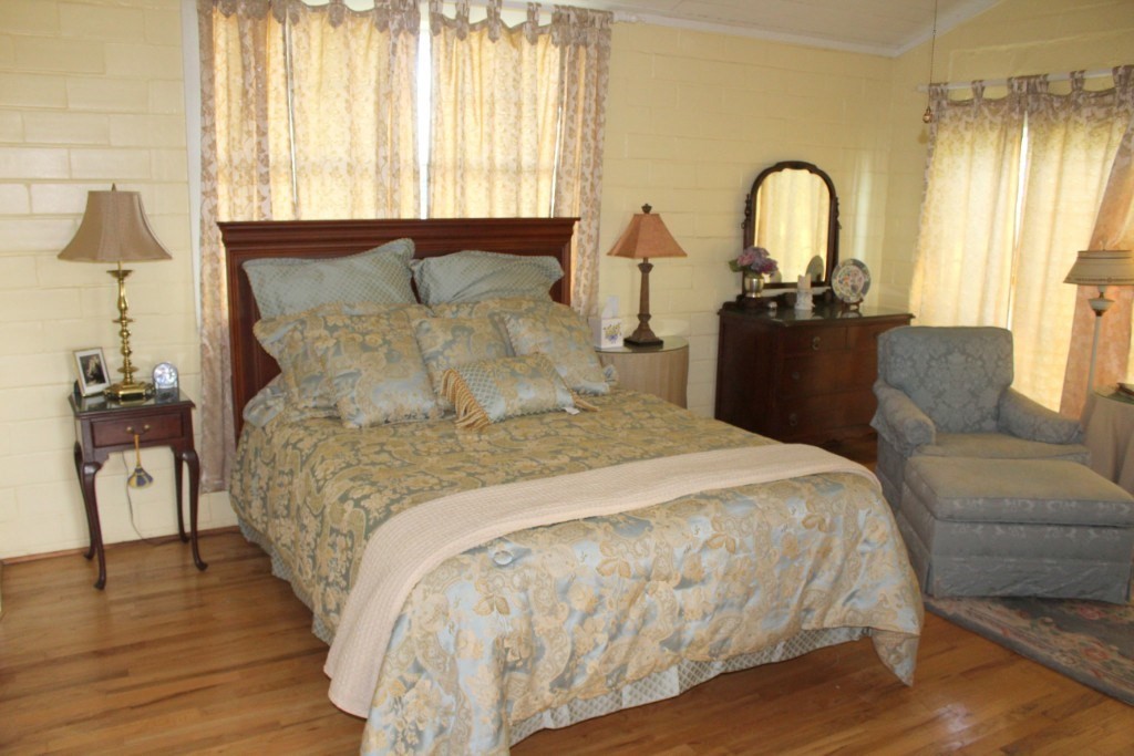 14808 Whitman Road, Unit 2 Washington, TX 77880 - Photo 8 of 11 a bedroom with a bed and a dresser with wooden floor