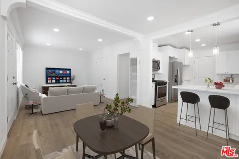 a living room with furniture and a dining table with kitchen view