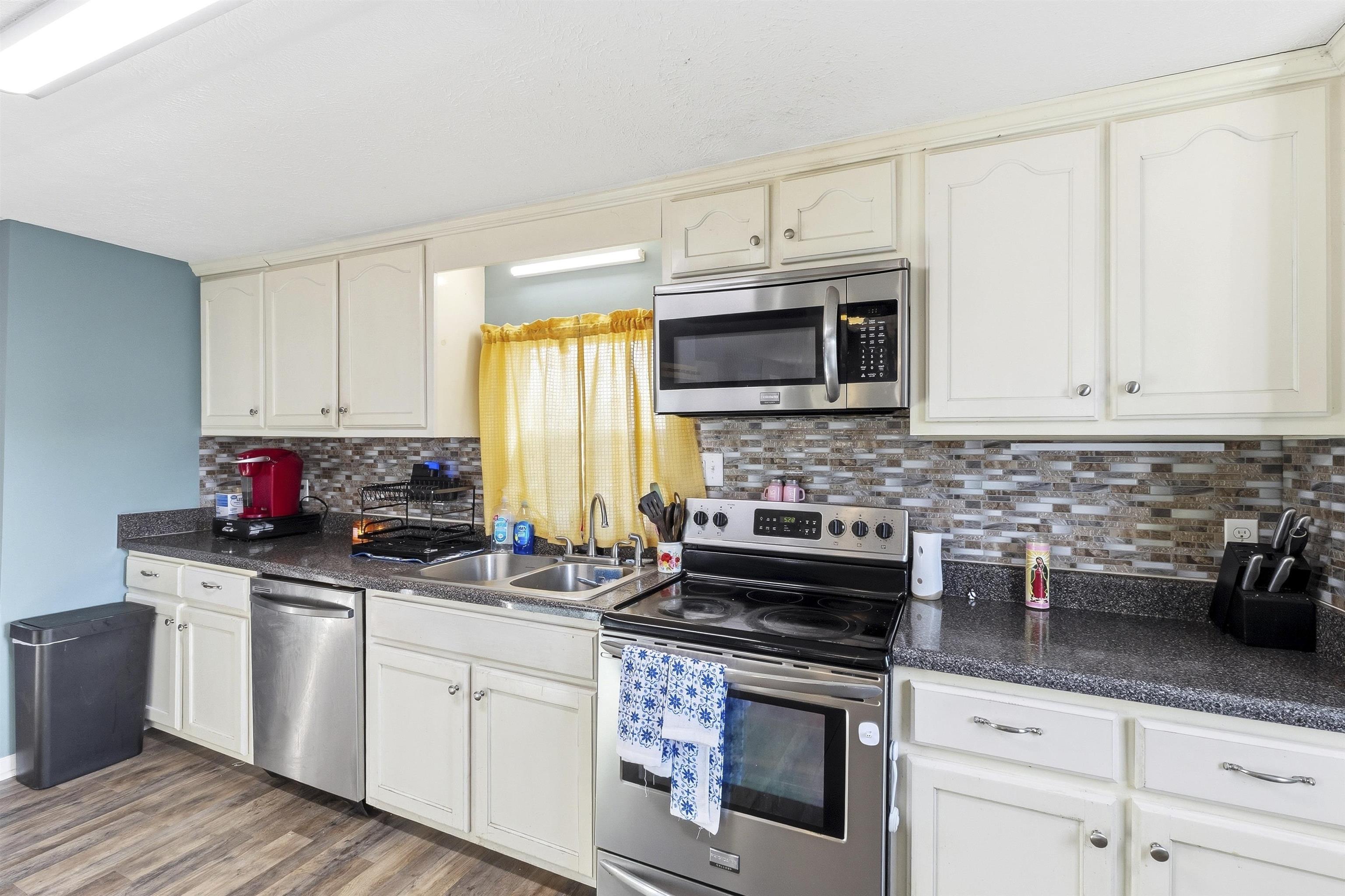 291 Central Curve Road Ripley, TN 38063 - Photo 4 of 13 a kitchen with stainless steel appliances white cabinets and a stove top oven