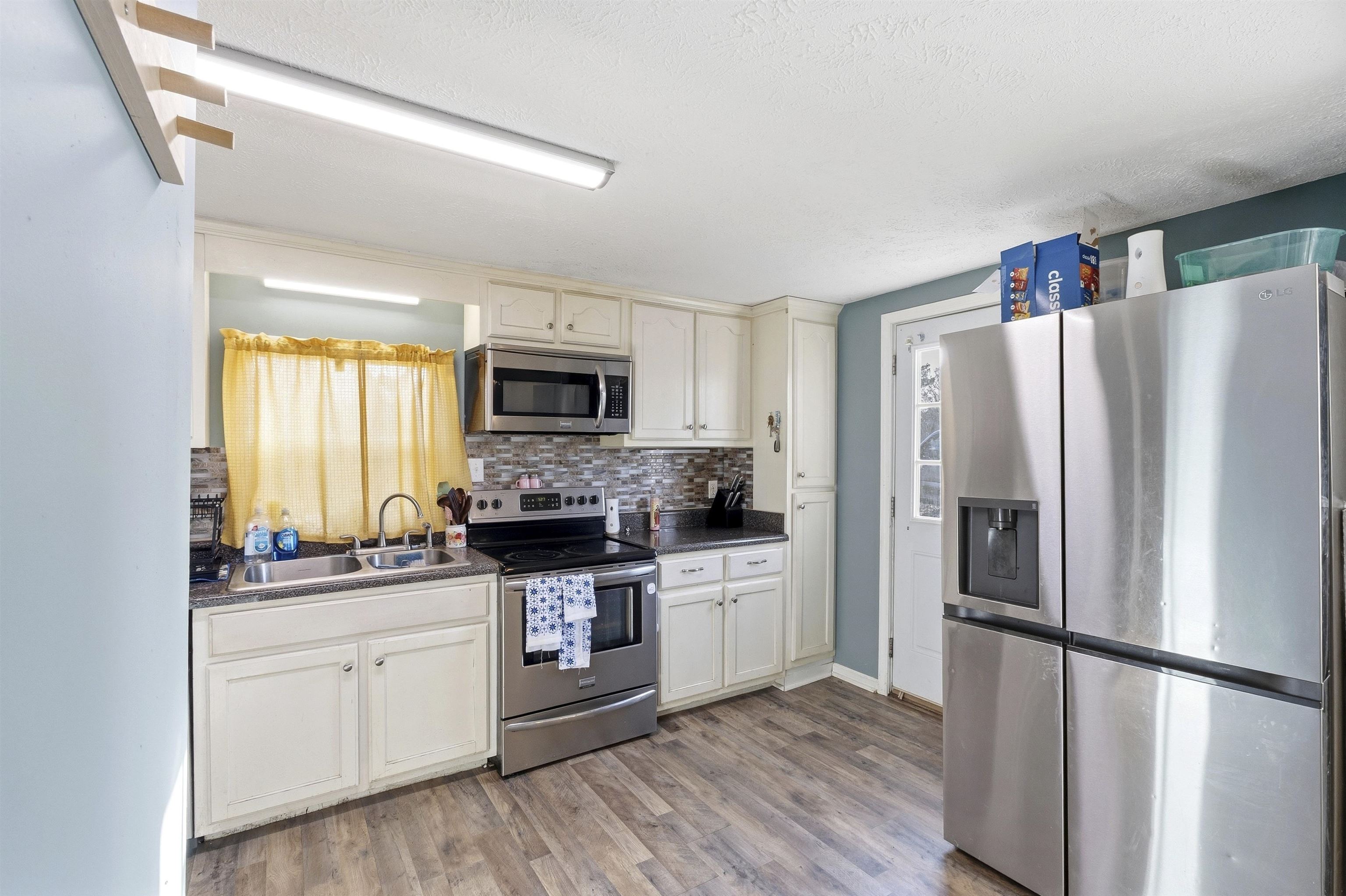 291 Central Curve Road Ripley, TN 38063 - Photo 5 of 13 a kitchen with white cabinets and stainless steel appliances