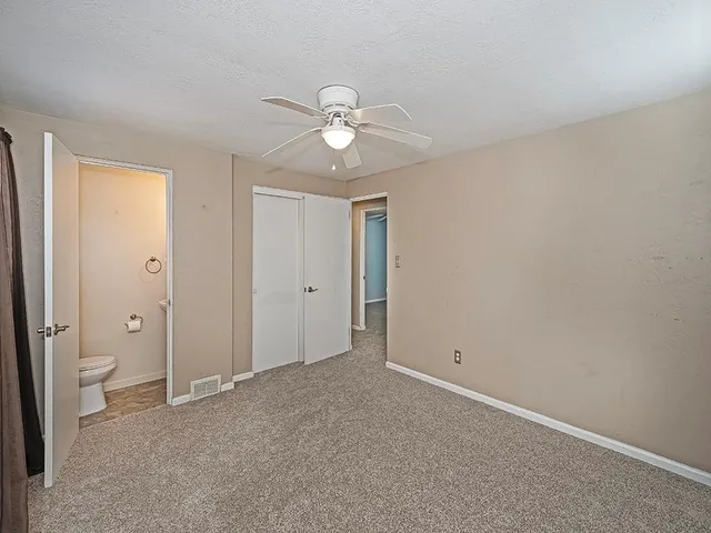 a view of room with closet and a ceiling fan